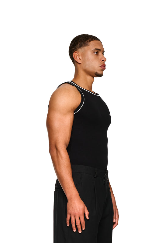 Nahaufnahme eines Unisex Contrast Tanktop Black mit elastischem Ripp-Stoff und gesticktem OLAKALA Icon auf der linken Brust, betont durch muskulöse Körperpartien.