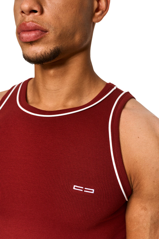 Nahaufnahme eines Mannes mit Contrast Tanktop Burgundy, zeigt elastischen Ripp-Stoff und gesticktes OLAKALA Icon auf der linken Brust.