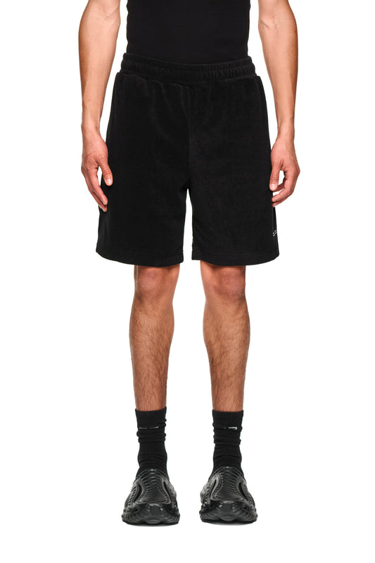 Nahaufnahme von Terry Shorts Black aus weichem Frottee mit elastischem Bund, Kordelzug, Leistentaschen und gesticktem Logo auf dem linken Bein.