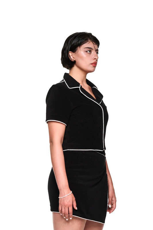 Nahaufnahme eines Terry Shirt Black Cropped aus weichem Frotteematerial mit 3D-Monogramm, kontrastierenden Paspelierungen und Logo-Stickerei auf der linken Brust.