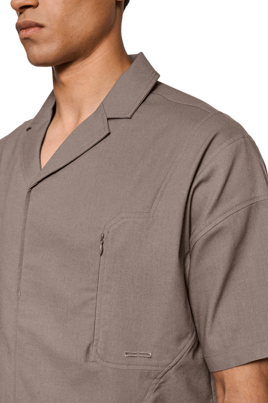Linen-Kurzarmhemd Beige mit Safari-Kragen, Brusttasche und Ton-in-Ton-Logo-Stickerei, Reißverschluss-Schlitzen vorne, unisex, bei OLAKALA erhältlich.