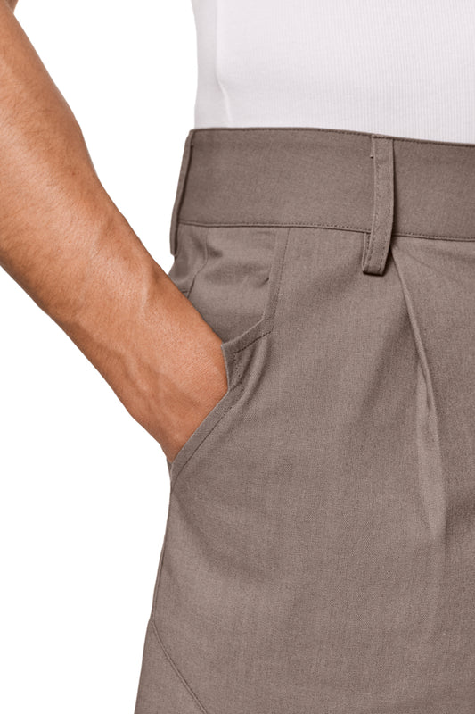 Linen Shorts Beige mit Bundfalten, französischen Taschen und asymmetrischem Eingriff. Unisex-Design mit versetzter Seitennaht und Schlitzen am Hosenbein, reguläre Passform.