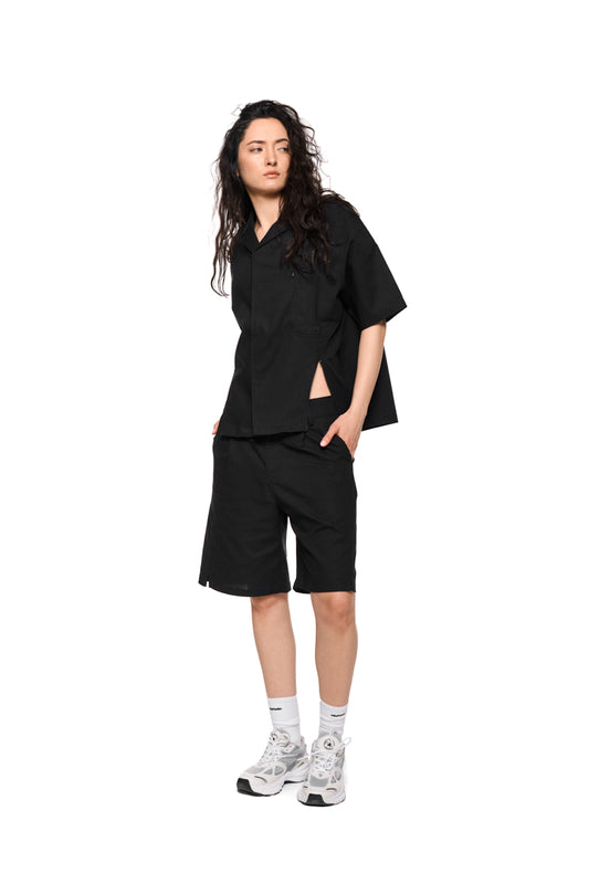 Kurzarm Leinenhemd mit Safari-Kragen, Brusttasche und Ton-in-Ton-Logo. Reißverschlussschlitze und Falten auf der Rückseite. Unisex, atmungsaktiv und pflegeleicht.