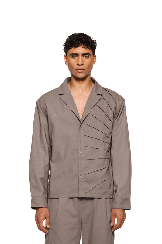Sun Linen blazer with asymmetric safari collar, removable shoulder padding and shirt button placket, shows sun detail and pleats; unisex, regular fit.