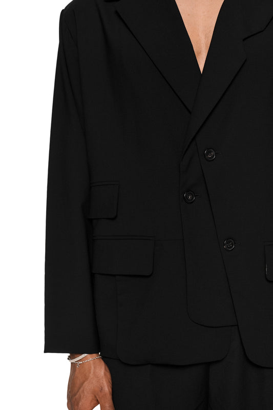 Asymmetric layered blazer with double-layered side, removable shoulder pads, several flap pockets and lapel collar, presented in the OLAKALA® online store.