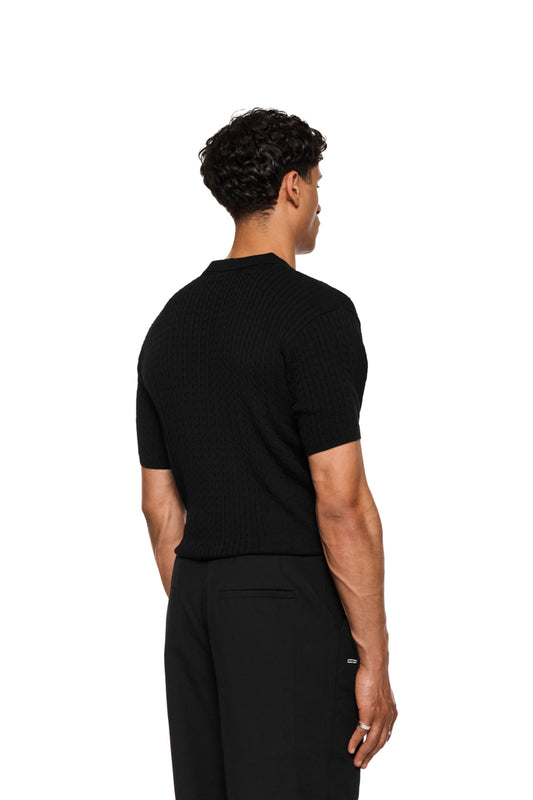 Schmales Zopfmuster-Poloshirt ohne Knopfleiste, mit doppellagigem Kragen, seitlichen Einsätzen und enganliegender Passform. Unisex-Design, passend zum eleganten Stil von OLAKALA.