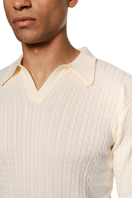 Schmal geschnittenes Poloshirt in Zopfmuster-Strick, doppellagiger Kragen, ohne Knopfleiste. Enganliegende Unisex-Passform.