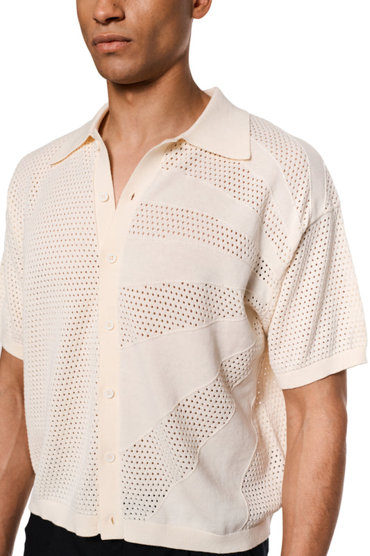 Sun Knit Shirt Creme mit feinem Lochstrickmuster, Sonnendetail vorne links, doppellagigem Kragen rechts, Knopfleiste in der Mitte, lockere Passform, unisex.