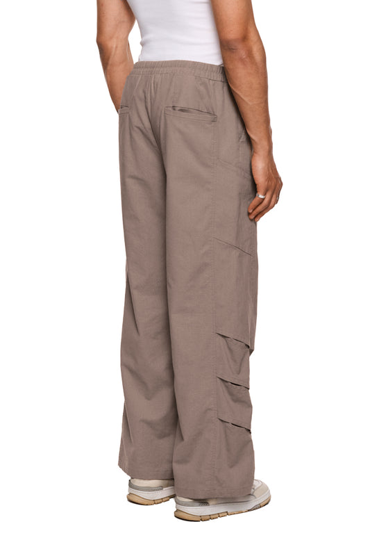 Unisex Leinen Gills Dress Pants mit elastischem Bund, französischen Taschen, Kiemenoptik-Lufteinlässen, Bundfalten vorne und Logo-Stickerei unterhalb der Tasche.