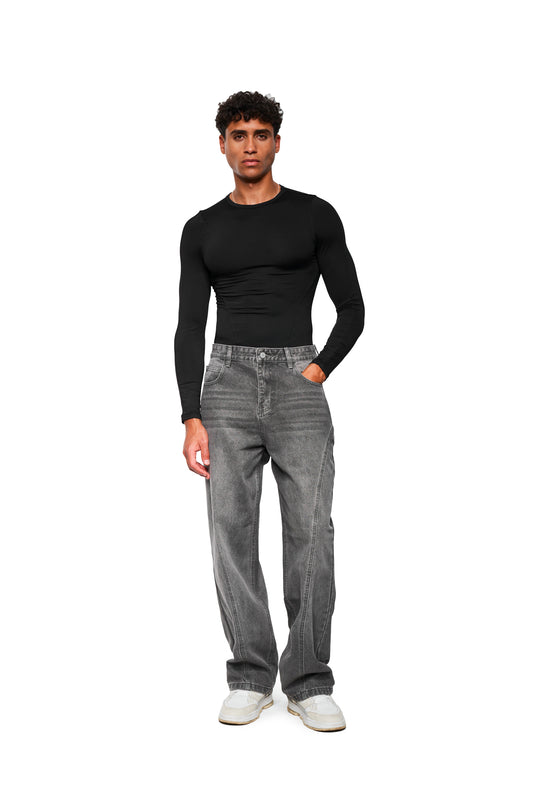 Männliches Model trägt das CC Core Slim Fit Longsleeve Black, ein körperbetontes Shirt aus Stretch-Material, kombiniert mit grauen Jeans und weißen Sneakers.