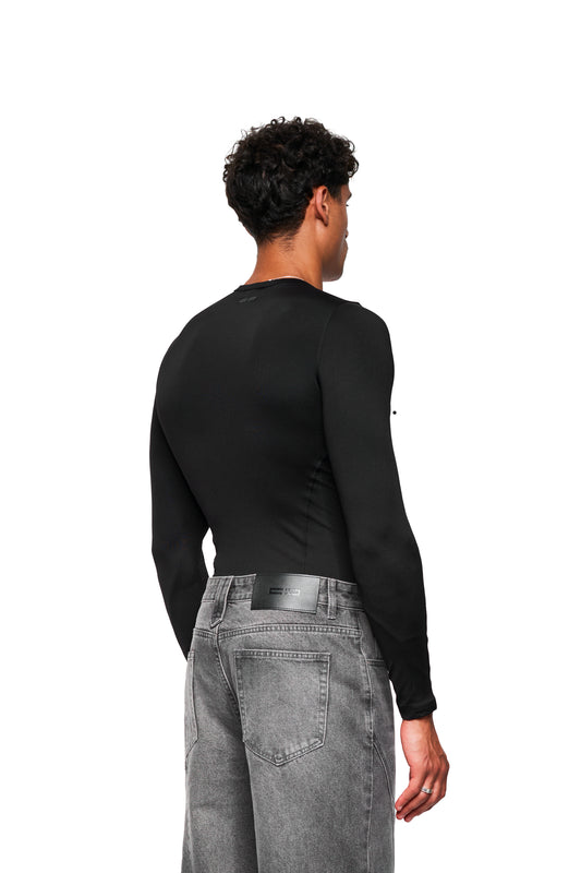 Rückansicht des CC Core Slim Fit Longsleeve Black, getragen von einem jungen Mann. Schmale Passform, bequemes Design, ideal kombinierbar.