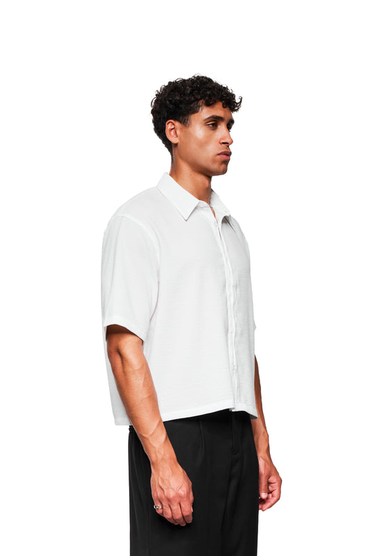 Junger Mann im Profil trägt das Crayon Summer Shirt Heart: weiß, kurz geschnitten, kubanischer Kragen, Herz-Grafik, luftiger Stoff, ideal für den Sommer.
