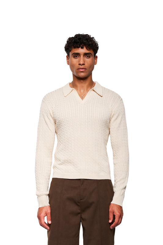 Young man in Exquisite Cable Knit Polo Cream with V-neck and cable knit pattern, combined with high-waisted brown pants, presented in the OLAKALA online store.