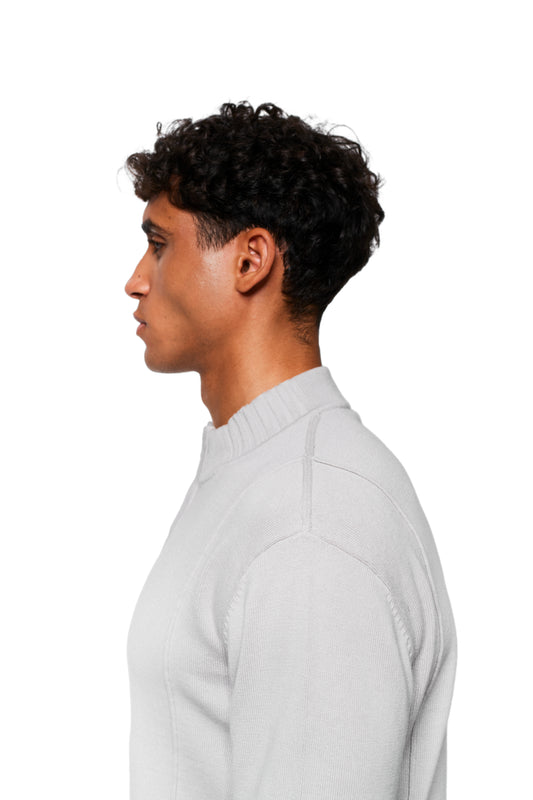 Junger Mann im Profil trägt Summer Knit Jacket Light Gray mit geripptem Mock-Neck-Kragen, ideal für laue Sommerabende, präsentiert im offiziellen OLAKALA® Onlineshop.