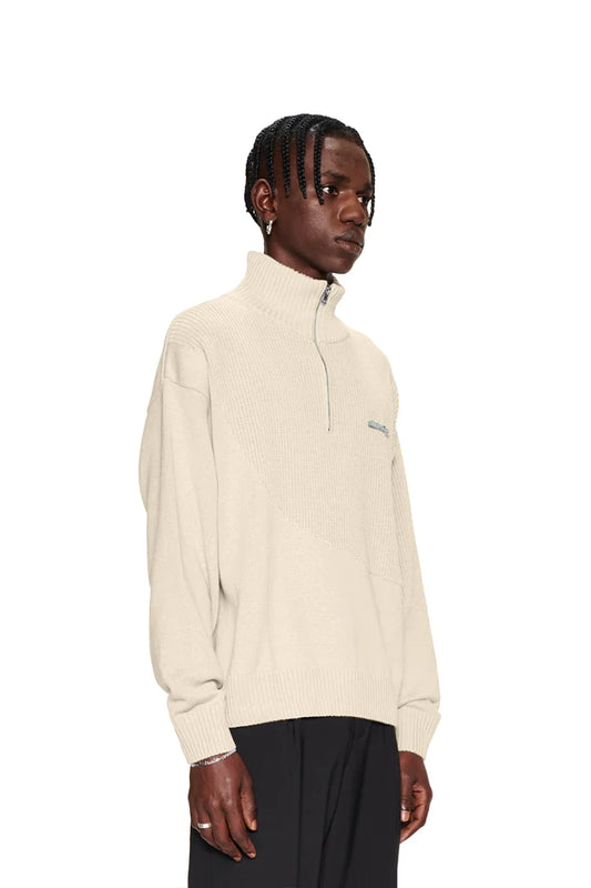 Mann in weißem Strickpullover mit halbem Reißverschluss, grobem und feinem Strickmix, überschnittenen Schultern und versetztem Saum, präsentiert im OLAKALA Onlineshop.