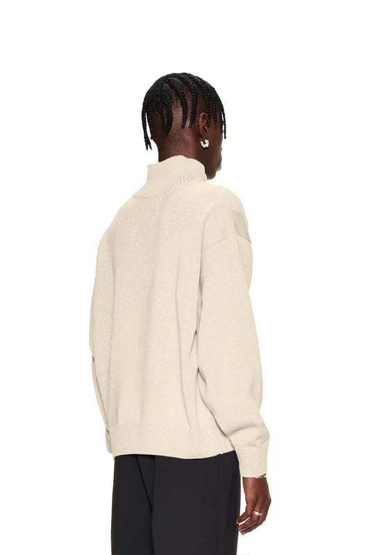Frau trägt CC Knit Halfzip Beige Pullover mit verschiedenen Strickmustern und überschnittenen Schultern, unisex Oversize-Passform.