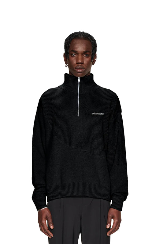Mann trägt CC Knit Halfzip Black, einen unisex Strickpullover mit verschiedenen Strickmustern und übergroßer Passform, featuring einen Metall-OLAKALA-Pin.
