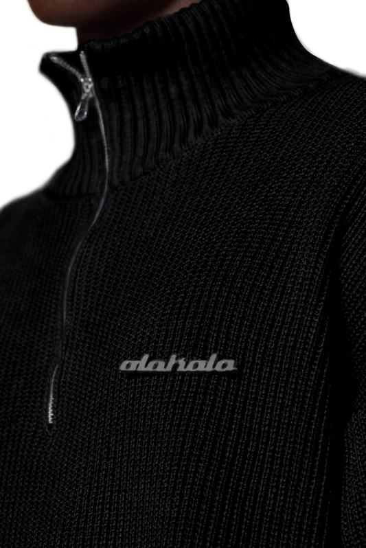 Nahaufnahme eines schwarzen Strickpullovers mit verschiedenen Strickmustern, überschnittenen Schultern und versetztem Saum, passend zur Beschreibung des CC Knit Halfzip Black.