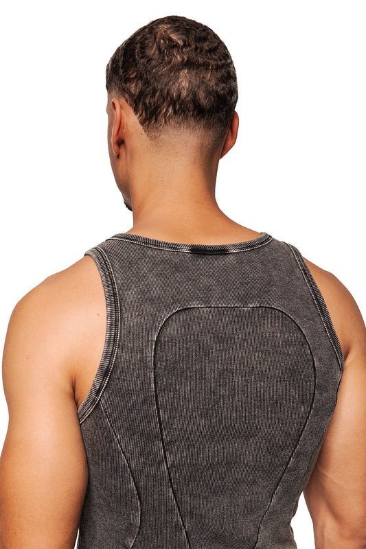 A man wears the Echoes tank top in anthracite with dividing seams at the back, a close fit and embroidered OLAKALA logo.