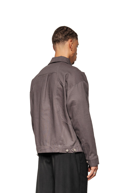 Back view of a man in the Heavy Anatomy Cotton Overshirt Gray with classic collar, button cuffs and adjustable waist tabs.