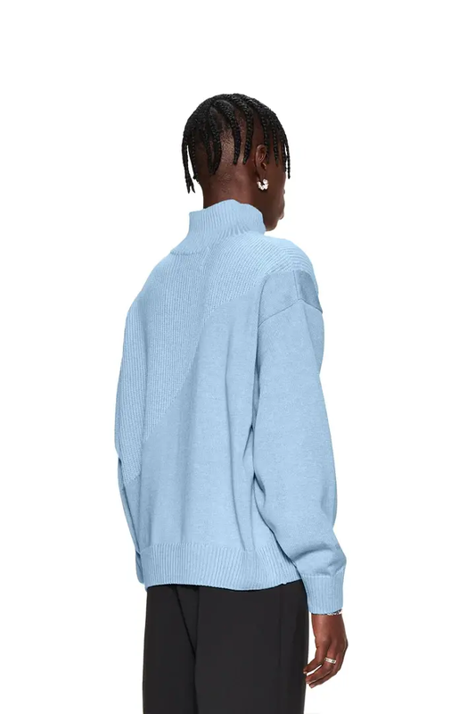 Frau trägt einen blauen CC Knit Halfzip mit verschiedenen Strickmustern und überschnittenen Schultern, präsentiert von OLAKALA.