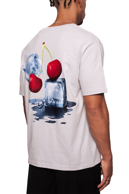 Mann trägt NC T-Shirt Gray Regular, Rückseite zeigt fotorealistische Kirschen auf Eiswürfel, schwarzes OLA KALA Logo vorne, Unisex-Design.