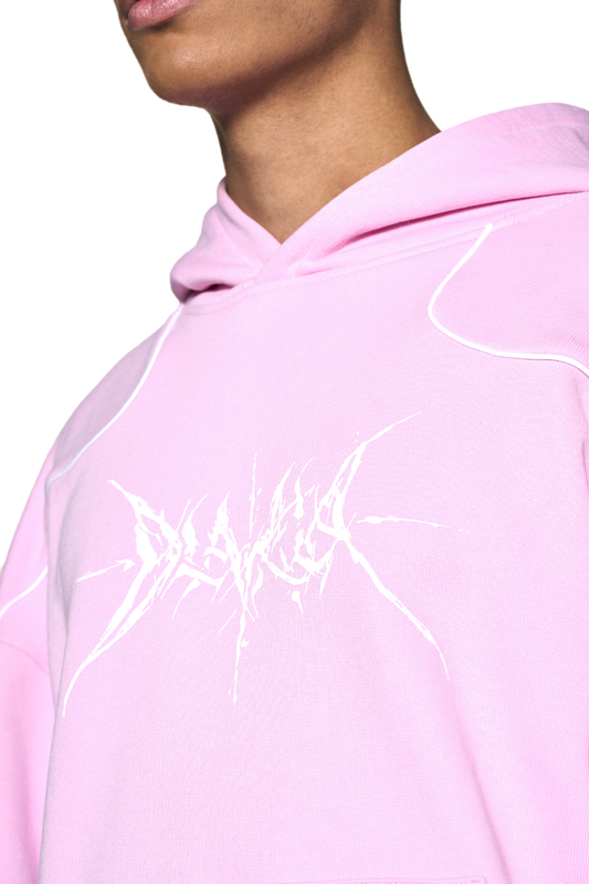 Person trägt Defect ID Hoodie Pink mit Siebdruck-Grafik auf der Brust, oversized und cropped Fit, mit Rippbündchen an Ärmeln und Saum.