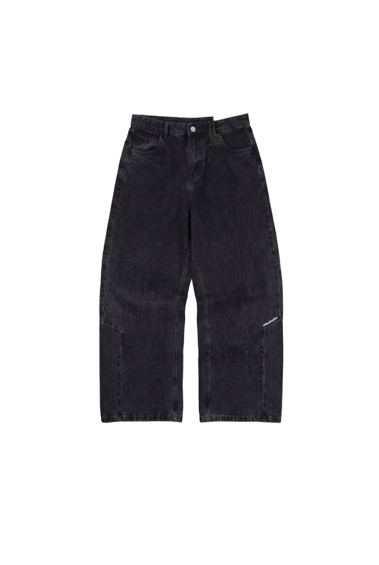 CC Black Loose Fit Denim Pants mit hohem Bund, asymmetrischer Optik, versetzter Seitennaht, Sticklogo, und markantem „Mittelfinger“-Patch auf Gürtelschlaufe, auf weißem Hintergrund.