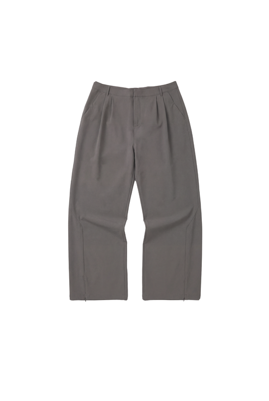 Exquisite Tech Pants Gray mit geradem Schnitt, Bundfalten und asymmetrischem Tascheneingriff, zeigt OLAKALA-Logo über Gesäßtasche, robustes Material für Komfort und Bewegungsfreiheit.