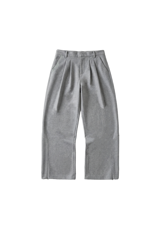 Exquisite Dress Pants Gray: Weite, hellgraue Hose mit Bundfalten, Seitentaschen, Gürtelschlaufen und gesticktem OLAKALA-Icon, aus festem Köper-Gewebe mit Reißverschluss am Saum.