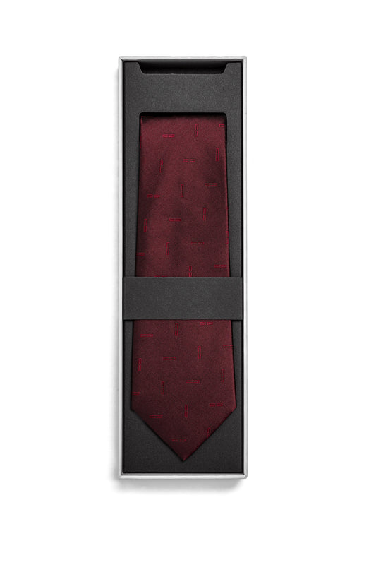 Monogram Tie Bordeaux in einer schwarzen Geschenkbox, zeigt feine rechteckige Stickmuster, fixiert durch ein schwarzes Band, unisex Design, ideal für stilvolle Anlässe.