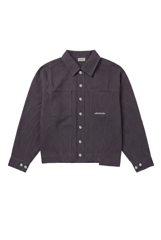 Heavy Anatomy Cotton Overshirt Gray mit klassischem Kragen, Druckknopf-Leiste, Brusttaschen, Ziernähten und gesticktem OLAKALA-Logo. Boxy, unisex, aus robustem Twill-Gewebe.