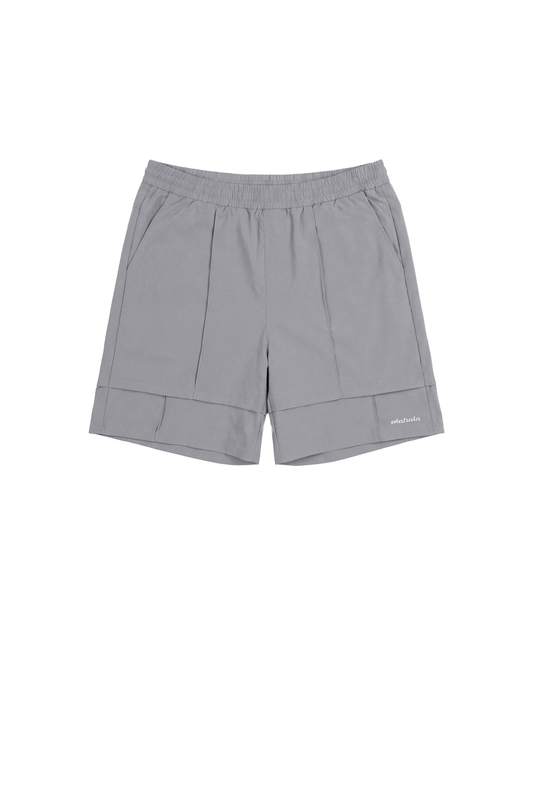 Track Shorts Gray mit elastischem Bund, seitlichen Taschen und gesticktem OLAKALA-Logo. Vielseitig einsetzbar dank wasserabweisendem Rip-Stop-Gewebe und lockerer Passform.