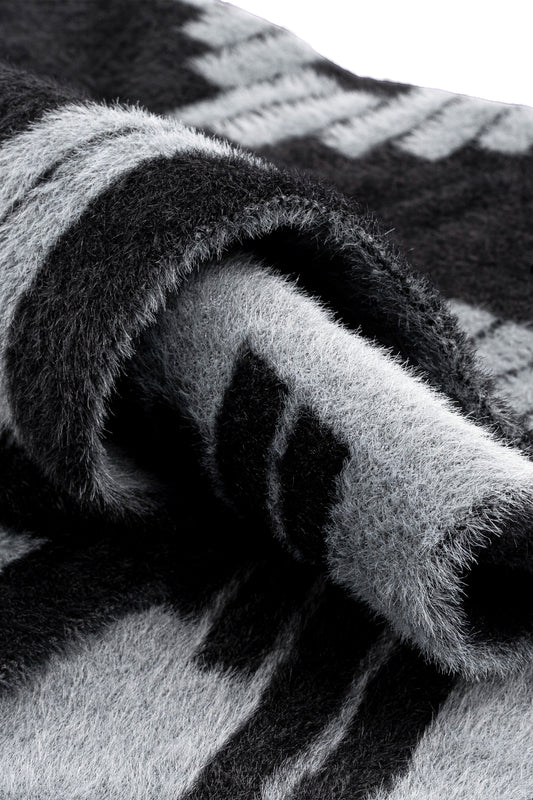 Nahaufnahme des Fuzzy Logo Schals mit OK-Logomuster, unisex, Länge 175 cm, Breite 40 cm, erhältlich im offiziellen OLAKALA® Onlineshop.