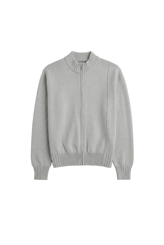 Sommer-Strickjacke in Hellgrau mit asymmetrischer Front, Metallreißverschluss und Rippenmuster. Unisex-Design, ideal für warme Abende, betont durch Inside-Out-Nähte.