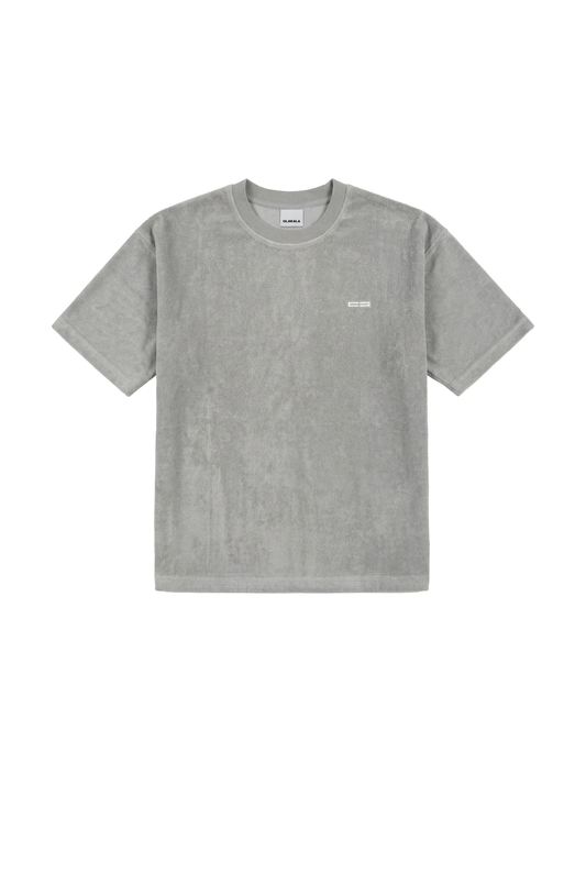 Graues Terry T-Shirt mit leicht strukturierter Oberfläche und kleinem weißen Logo auf der linken Brust, unisex, für vielseitige Styling-Optionen.