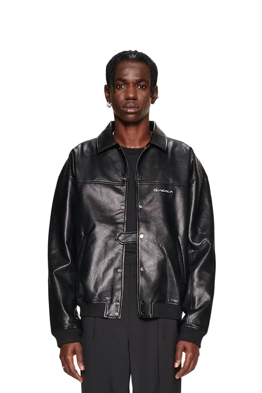 Mann trägt CC Leather Jacket Black OLD aus veganem Lederimitat mit Reißverschluss, Druckknöpfen und gesticktem OLAKALA-Logo, Oversized Passform.