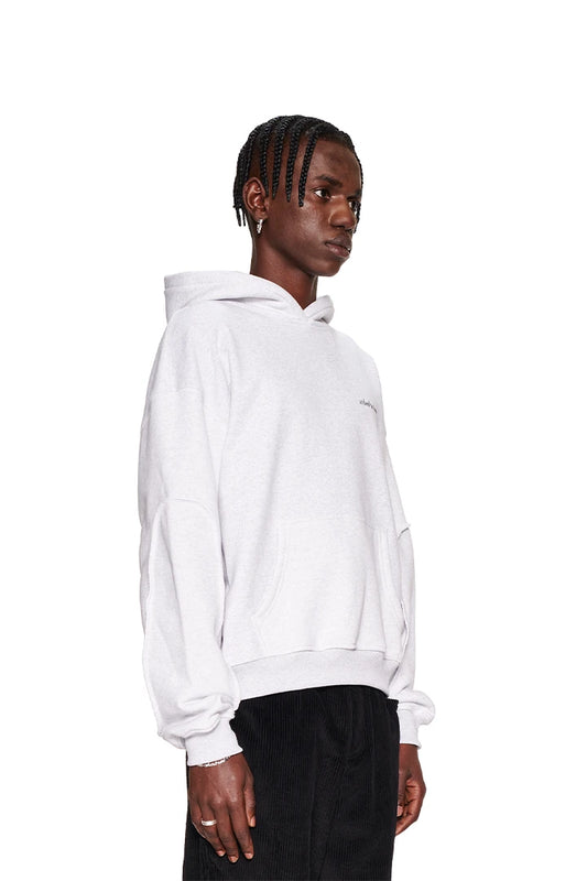 Man in the white CC Essential Hoodie Gray Melange with embroidered OLAKALA logo on the chest and ribbed cuffs and hem.