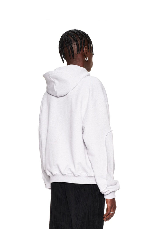 A woman wears the CC Essential Hoodie Gray Melange with ribbed cuffs, dividing seams and embroidered OLAKALA logo on the chest.