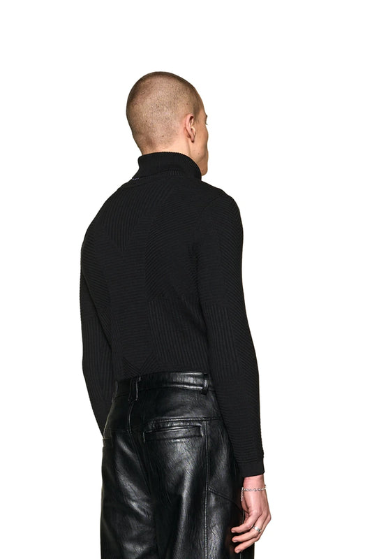Anatomy Rollkragenpullover in eng anliegendem Schnitt, getragen von einem Mann mit schwarzer Hose, zeigt das OLA KALA Tag am Kragen. Unisex-Design.
