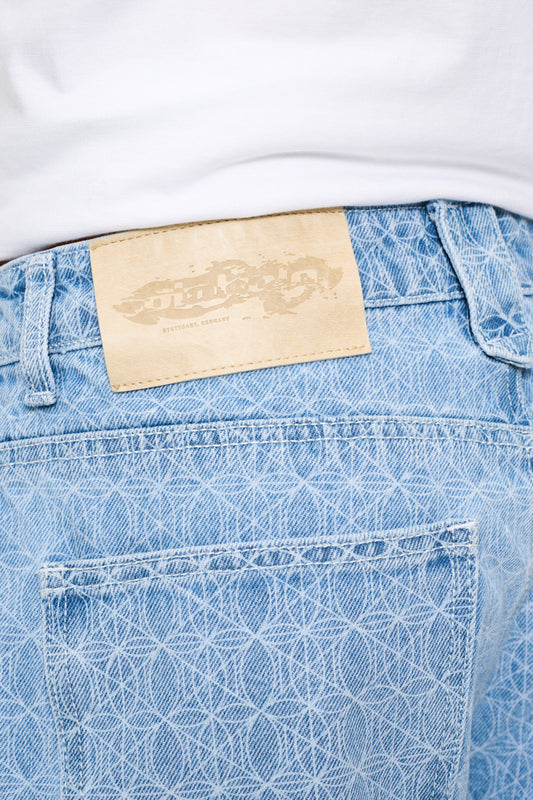 CC Blue Monogram Denim Pants mit geprägtem OLAKALA-Patch und versetzter Seitennaht, präsentiert in hochwertigem, lockerem 14 oz Denim-Gewebe.