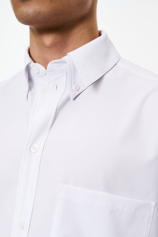 CC Button Shirt White mit doppeltem Kragen, Brusttasche mit Metall-Logo und Teilungsnähten, oversized Unisex-Passform, Detailansicht eines Knopfes.