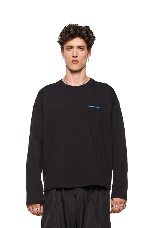 Mann trägt Synergy Embroidered Longsleeve Black mit gesticktem Logo auf der Brust und Ripp-Kragen, oversized Passform.