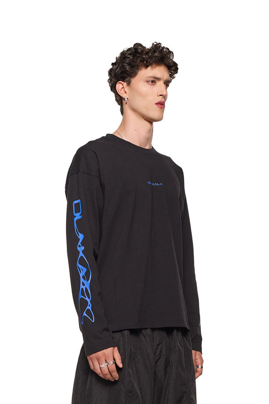 Mann im schwarzen Synergy Longsleeve Shirt mit OLAKALA-Siebdruck auf Brust und Ärmeln, zeigt eine lässige Oversize-Passform.