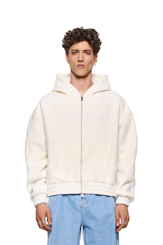 Mann trägt Isolation Zip Hoodie Beige mit 2-Wege-Reißverschluss, Teilungsnähten, Eingriffstaschen und elastischen Bündchen. Oversized Passform, Unisex-Design.