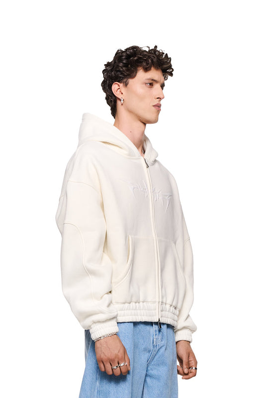 Mann im weißen Isolation Zip Hoodie Beige mit 2-Wege-Reißverschluss, Teilungsnähten und elastischen Bündchen, trägt Ringe; oversized Unisex-Design.