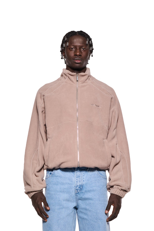 Mann trägt die Fleece-Jacke Mocha Brown mit Paspeln, Eingriffstaschen, elastischen Bündchen, gesticktem OLAKALA-Logo und Oversize-Schnitt.