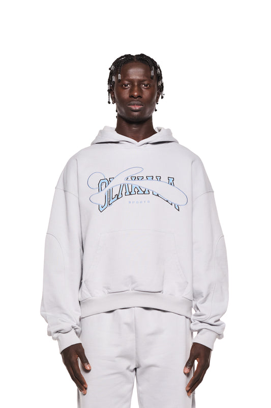 Mann trägt weißen Sports Hoodie Gray mit gestickter OLAKALA Sports Grafik. Oversized Passform, Ripp-Bündchen, Teilungsnähte an Ärmeln. Unisex-Design.