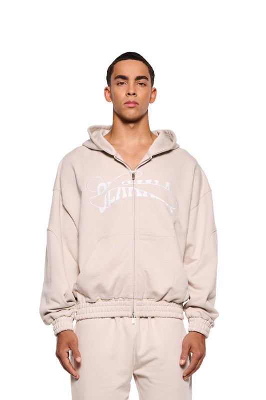 Ein Mann trägt den OLAKALA Sports Zip Hoodie Beige mit gesticktem Logo und 2-Wege-Reißverschluss, elastischen Bündchen und oversized Passform.