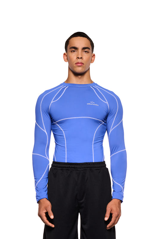 Man in blue Sports Anatomy Tech Top Blue with OLAKALA Sports logo on the chest and figure-hugging fit, presented by OLAKALA.